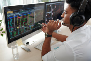 employee in front of multiple monitors displaying bond rates