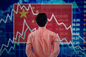 a man watching the chinese flag with earning call transcripts chart in background